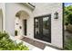 Close-up of a home's entry, showcasing double doors and intricate brick detailing around the arched entryway at 528 Greely St, Orlando, FL 32804