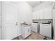 Well-lit laundry room equipped with a washing machine, dryer, cabinetry, and granite countertops at 528 Greely St, Orlando, FL 32804