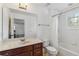 Well-lit bathroom with a vanity, toilet, and shower with tile surround at 530 Harriswood Ct, Davenport, FL 33837