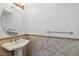 A pedestal sink, round mirror, and earth tone tile work makes for a clean aesthetic at 530 Harriswood Ct, Davenport, FL 33837