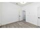 A bright room with gray wood-look flooring, with an open door to another room at 530 Harriswood Ct, Davenport, FL 33837