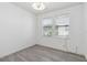 A bright room with gray wood-look flooring, and two windows to bring in the natural light at 530 Harriswood Ct, Davenport, FL 33837