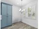 Cozy dining area featuring wood-look tile flooring, plantation shutters, and modern chandelier at 530 Harriswood Ct, Davenport, FL 33837