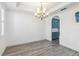 An open dining room with wood-look tile floors, a decorative chandelier, and arched entryway to the kitchen at 530 Harriswood Ct, Davenport, FL 33837