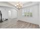 Elegant dining space with wood-look tile flooring, crown molding, chandelier, and natural light at 530 Harriswood Ct, Davenport, FL 33837