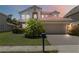 Charming two-story home boasts a red tile roof, neutral stucco exterior, and a well-manicured front yard at 530 Harriswood Ct, Davenport, FL 33837