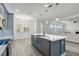 Modern kitchen with white countertops, blue cabinets, pendant lights, and an open layout to the living area at 530 Harriswood Ct, Davenport, FL 33837