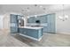 Stylish kitchen with blue cabinets, a center island, stainless steel appliances, and wood-look tile flooring at 530 Harriswood Ct, Davenport, FL 33837