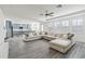 Expansive living area with wood-look tile, a large white sofa, and an open-concept design to the kitchen at 530 Harriswood Ct, Davenport, FL 33837