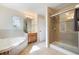 Bathroom featuring a glass shower, soaking tub, and wood cabinets at 5350 Penway Dr, Orlando, FL 32814