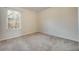 An empty bedroom featuring carpet flooring, neutral paint, and a large window at 5350 Penway Dr, Orlando, FL 32814