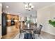 Open-concept dining area with a round wood table, seating for four, and a view of the modern kitchen at 5350 Penway Dr, Orlando, FL 32814