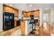 A kitchen with wooden cabinets, an island with a breakfast bar, and black appliances offers a modern aesthetic at 5350 Penway Dr, Orlando, FL 32814