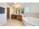 Large bathroom with double vanity, soaking tub, tiled shower, and neutral tile flooring at 5350 Penway Dr, Orlando, FL 32814
