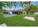Backyard featuring lush green lawn, covered patio, and mature shade trees at 543 Silver Crse, Ocala, FL 34472