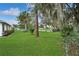 A view of the backyard shows perimeter planting, mature trees and a fenced boundary at 543 Silver Crse, Ocala, FL 34472