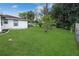 A view of the backyard shows a well manicured lawn and perimeter planting at 543 Silver Crse, Ocala, FL 34472