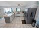 Bright kitchen features white cabinetry, a stainless steel refrigerator, and tiled floors at 543 Silver Crse, Ocala, FL 34472