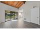 Open-concept living room with wood ceilings, lots of natural light, and access to a balcony at 6120 Peregrine Ave # A08-2, Orlando, FL 32819