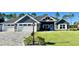 Beautiful home featuring a well-manicured lawn, attractive landscaping, and a three-car garage at 6449 Sw 180Th Cir, Dunnellon, FL 34432
