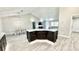 Kitchen island with breakfast bar, dark cabinets, and a view of living spaces at 6449 Sw 180Th Cir, Dunnellon, FL 34432
