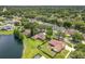 Aerial view of the home near a serene lake, surrounded by lush greenery at 700 Wyckliffe Pl, Winter Springs, FL 32708
