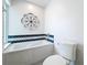 Bathroom featuring a soaking tub with tile accents and a toilet at 700 Wyckliffe Pl, Winter Springs, FL 32708