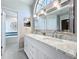 Spacious bathroom featuring a double sink vanity with granite countertop, large mirror, and soaking tub at 700 Wyckliffe Pl, Winter Springs, FL 32708