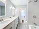 Well lit bathroom featuring a double sink vanity, gray tile floors, and white tile shower with glass door at 700 Wyckliffe Pl, Winter Springs, FL 32708