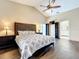 Bedroom featuring a ceiling fan, wood floors, decorative headboard, and ensuite bathroom entrance at 700 Wyckliffe Pl, Winter Springs, FL 32708