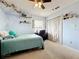 Bedroom with blue walls, ceiling fan, and cozy furnishings at 700 Wyckliffe Pl, Winter Springs, FL 32708