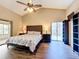 Bright bedroom featuring a high ceiling, ceiling fan, wood floors, sliding glass door and decorative headboard at 700 Wyckliffe Pl, Winter Springs, FL 32708