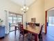 Cozy dining room with hardwood floors, a chandelier, and sliding glass doors leading to a sunroom at 700 Wyckliffe Pl, Winter Springs, FL 32708