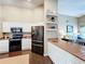 Charming kitchen featuring stainless steel appliances, stylish open shelving, and sleek countertops at 700 Wyckliffe Pl, Winter Springs, FL 32708