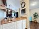 Open-concept kitchen with bar seating, white cabinets, and views into the living area with a fireplace at 700 Wyckliffe Pl, Winter Springs, FL 32708