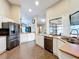 Bright kitchen featuring stainless steel appliances, white cabinets, and a large window at 700 Wyckliffe Pl, Winter Springs, FL 32708