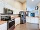 Kitchen with stainless steel appliances, white cabinetry, and tile floors at 700 Wyckliffe Pl, Winter Springs, FL 32708