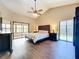 Spacious main bedroom featuring a tray ceiling, large windows, and private access to the lanai at 700 Wyckliffe Pl, Winter Springs, FL 32708