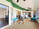 Well-lit sunroom with a white bench, wicker chairs, and multiple access points to interior and exterior at 700 Wyckliffe Pl, Winter Springs, FL 32708