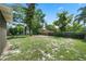 The large backyard is bordered with trees and a wooden fence at 709 Suzette Dr, Ocoee, FL 34761