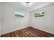 Bright bedroom with wood-look flooring, white walls and trim, and two windows for natural light at 709 Suzette Dr, Ocoee, FL 34761