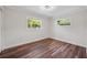 Bright bedroom featuring wood flooring and natural light from two windows at 709 Suzette Dr, Ocoee, FL 34761