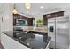 Kitchen featuring stainless appliances, dark cabinets, and granite countertops at 709 Suzette Dr, Ocoee, FL 34761