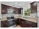 Updated kitchen boasts stainless steel appliances and dark wood cabinets at 709 Suzette Dr, Ocoee, FL 34761