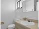 Simple bathroom with a white toilet, sink, and mirror, accented by a small window and minimalist decor at 7344 Swallow Run # 7344, Winter Park, FL 32792