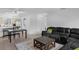An open-plan living room featuring a black sofa and kitchen at 7344 Swallow Run # 7344, Winter Park, FL 32792
