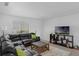 A living room featuring a black leather sofa and a television at 7344 Swallow Run # 7344, Winter Park, FL 32792
