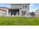 Spacious backyard with a screened-in patio, rocking chairs, and outdoor grill at 7603 Taormina Way, Clermont, FL 34714