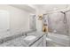 Modern bathroom with granite countertop, white vanity, and tub-shower combination at 7603 Taormina Way, Clermont, FL 34714