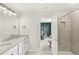Bathroom with granite countertops, dual sinks, walk-in shower and a view of the bedroom at 7603 Taormina Way, Clermont, FL 34714